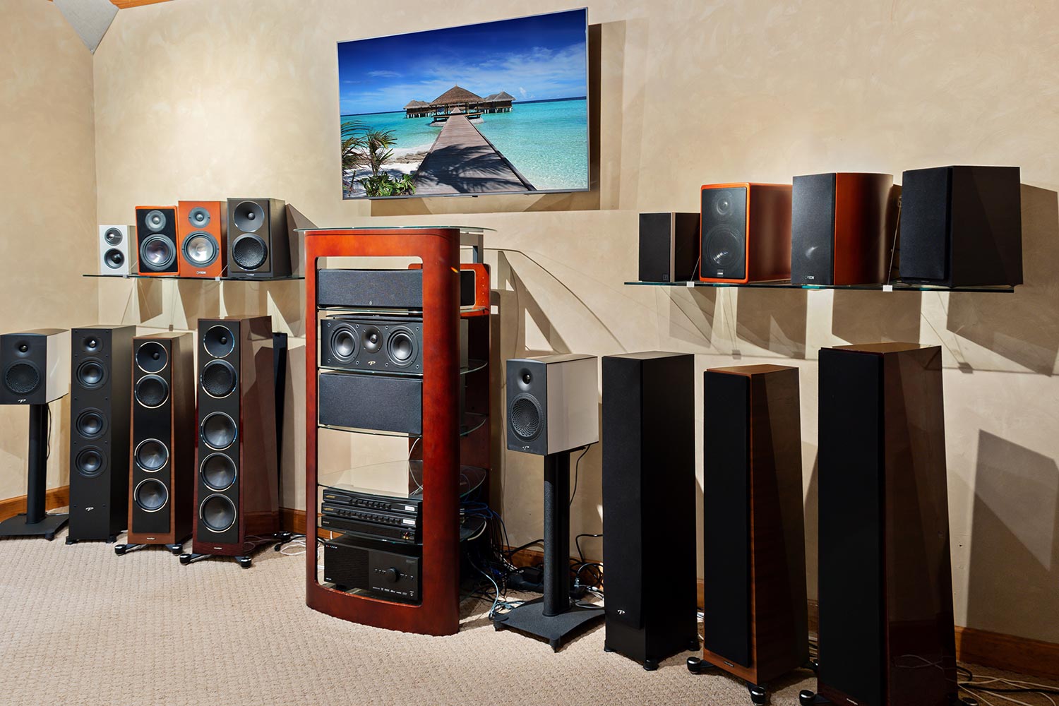 Collection of various freestanding and bookshelf speakers below a wall-mounted television