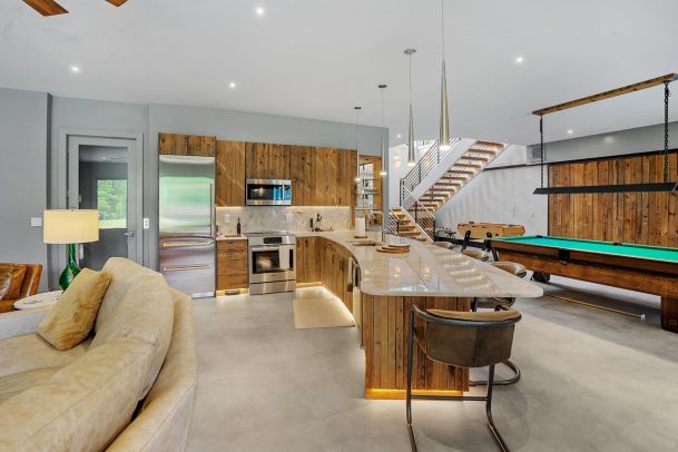 Modern kitchen with wood cabinets and a pool table nearby