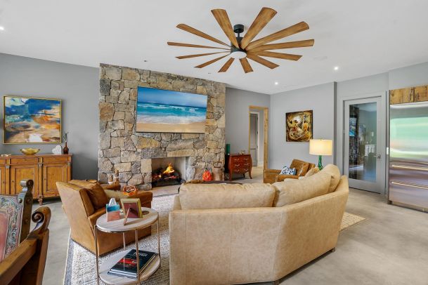 Living room with leather sofas a stone fireplace and wall mounted tv