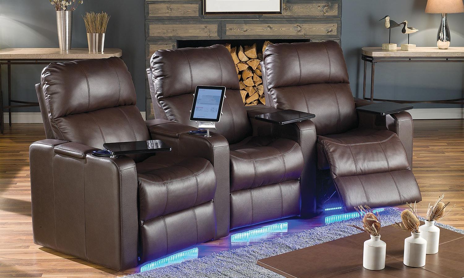 three brown leather theater seats facing a stone fireplace