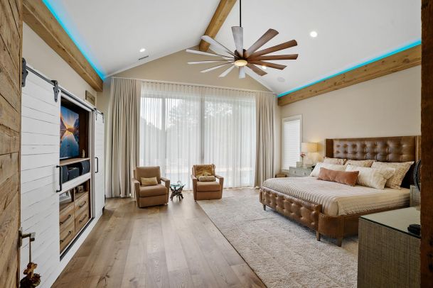 Bedroom with a leather bed and sliding barn doors over TV