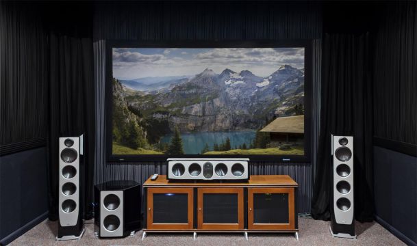 Dedicated home theater with large screen, speakers, and AV console