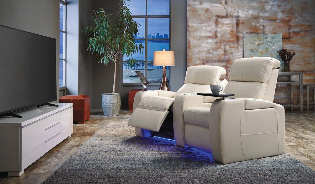 two cream leather theater seats in a loft with a city view
