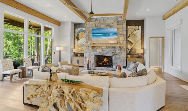 Bright living room with stone fireplace TV and white sectional sofa