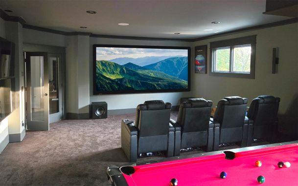 Multipurpose room with a red pool table, leather seating, and large screen