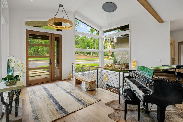 Bright modern entryway with grand piano and large view windows