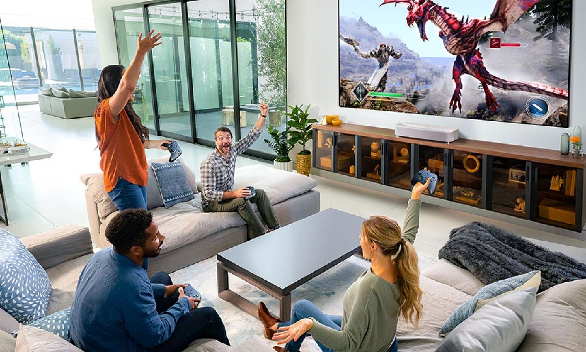 Four people playing video games on a large projection screen