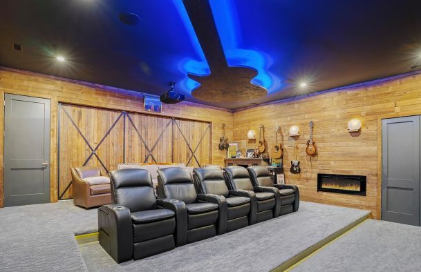 Home theater with black leather recliners and a guitar shaped ceiling light
