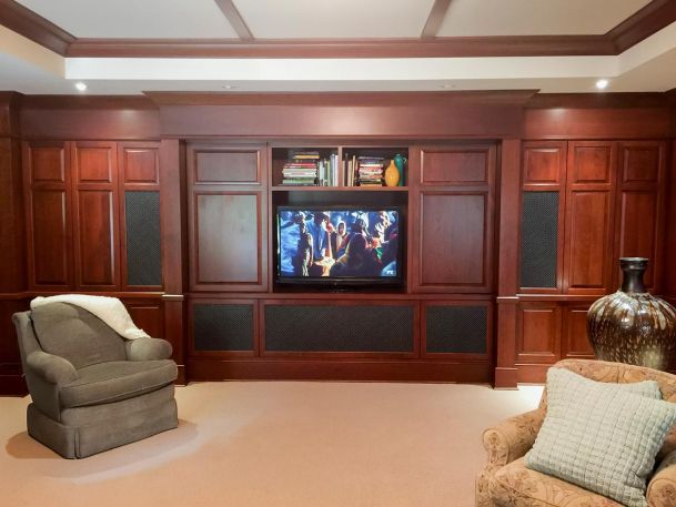 Dark wood entertainment center with TV and two armchairs