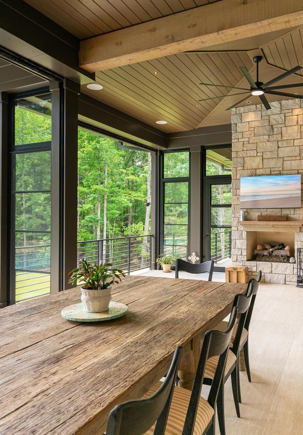 Covered outdoor dining patio with rustic table and fireplace