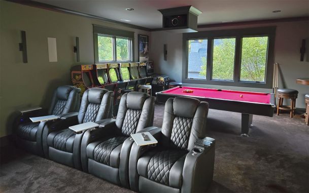 Game room featuring black theater seating a red pool table and arcade machines