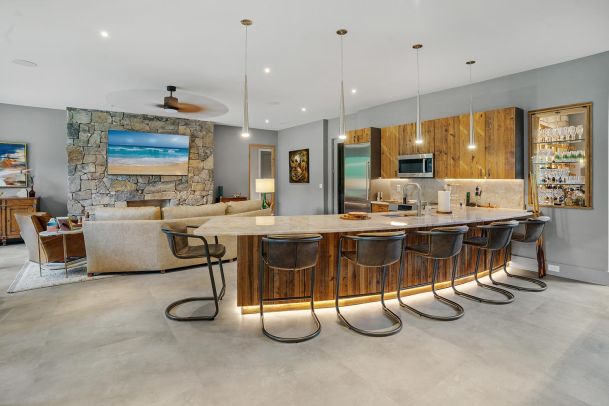Open concept living room and kitchen area with a stone fireplace