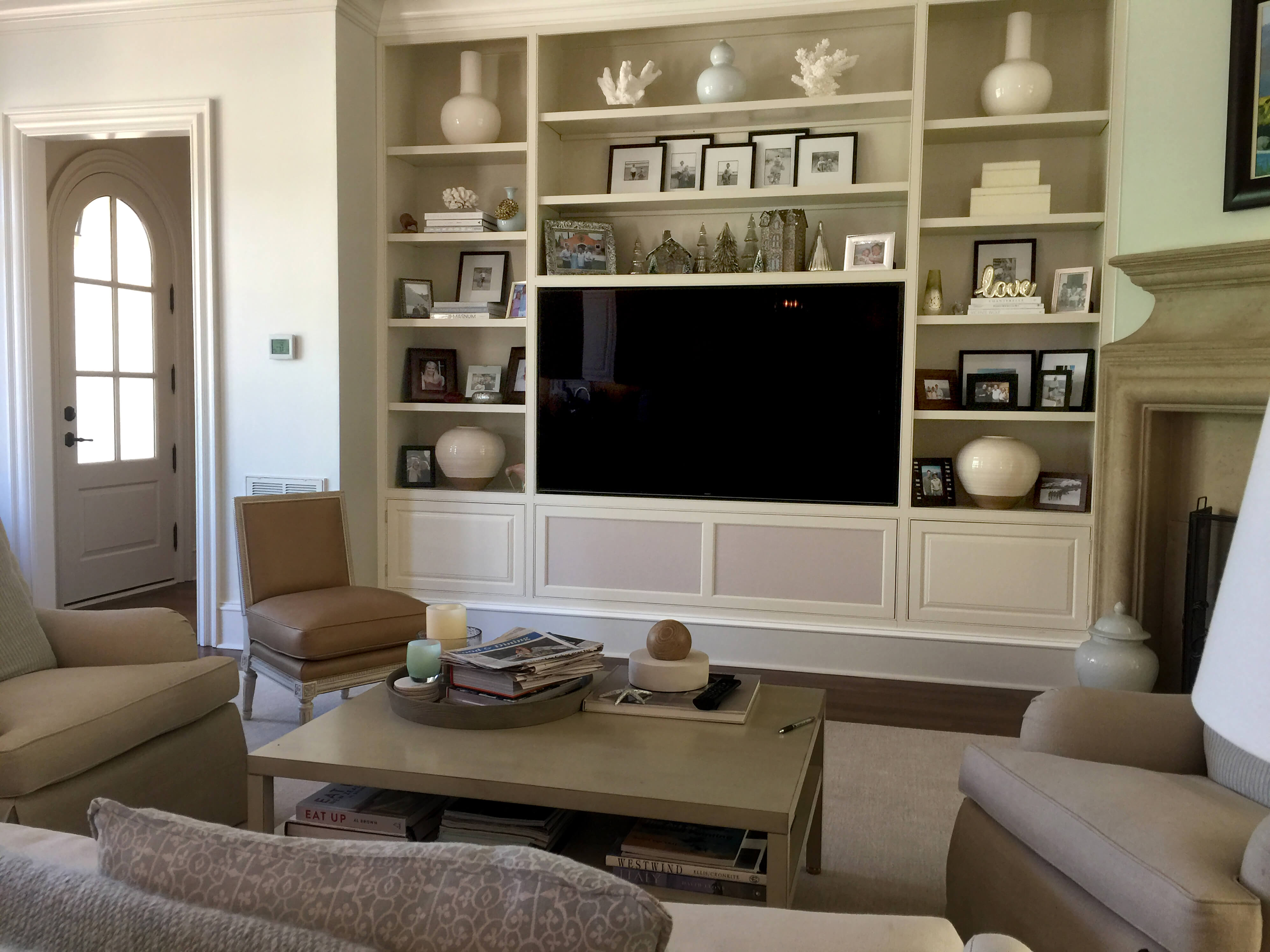 Cozy living room with a large TV, built-in shelves, and comfortable seating.