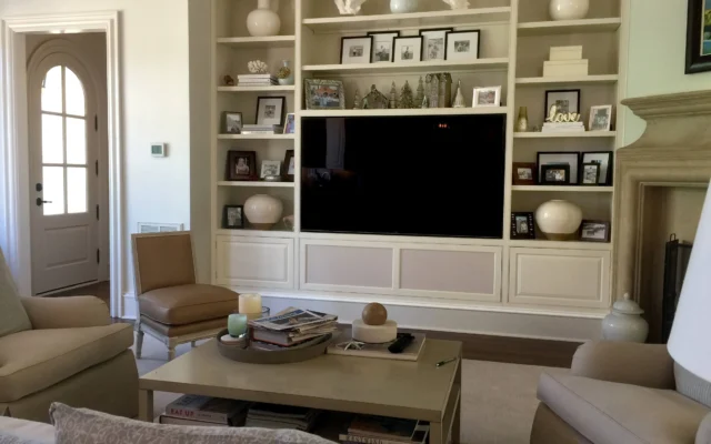 Cozy living room with a large TV, built-in shelves, and comfortable seating.